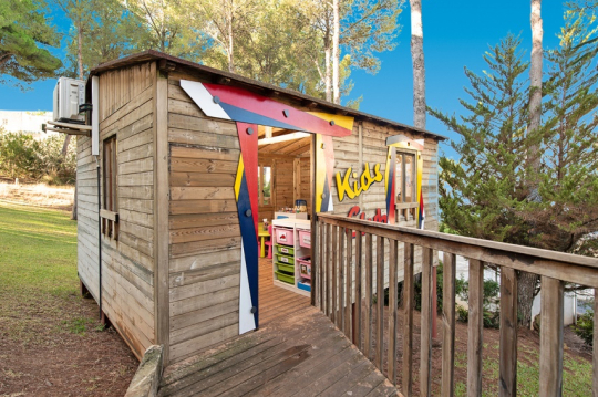Holzh&uuml;tte mit offener T&uuml;r und der Aufschrift Kids Club